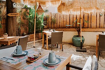 A patio with tables and chairs and a sign that says pitango