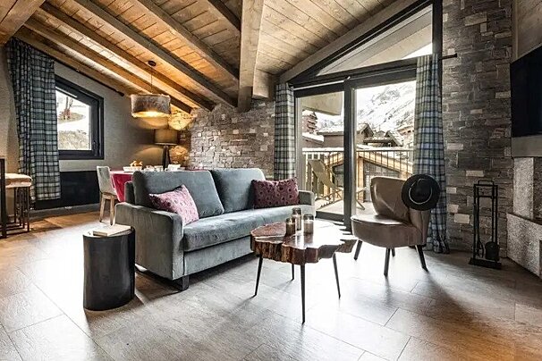 A living room with a couch and chairs and a fireplace