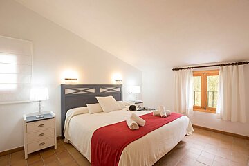 A bedroom with a large bed and a window