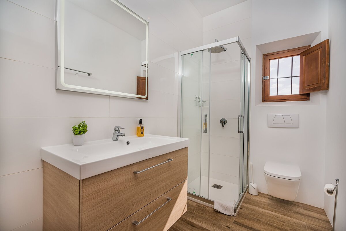 A bathroom with a sink a toilet and a shower