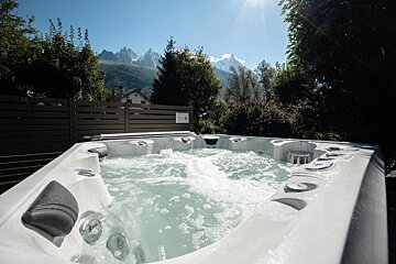 A large white hot tub with mountains in the background