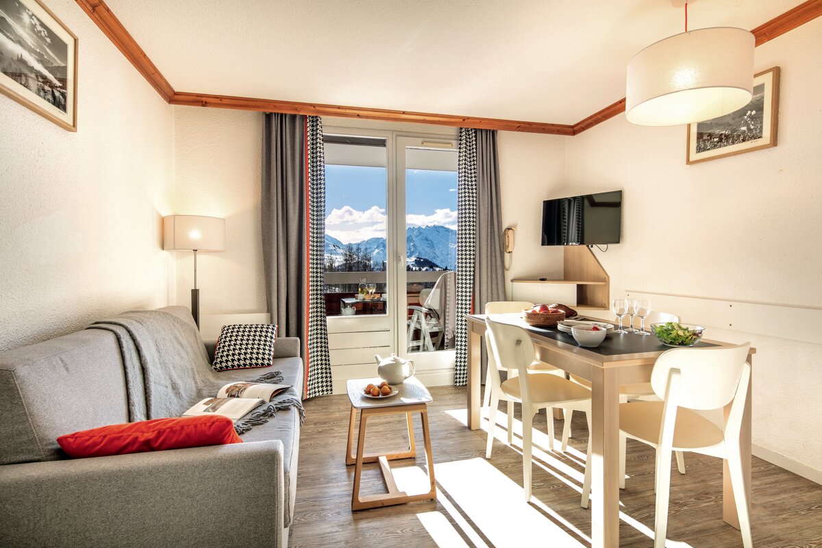 A living room with a couch and a table and chairs