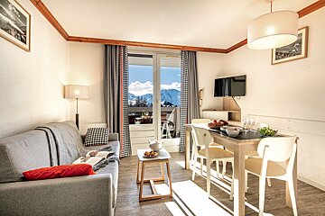 A living room with a couch and a table and chairs