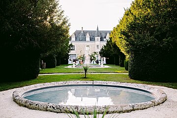A fountain in a garden with a castle in the background