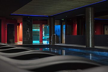 A swimming pool with a sauna in the background