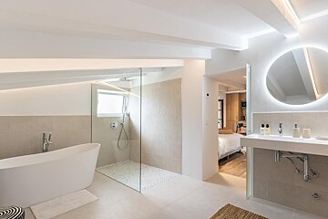 A bathroom with a walk in shower and a bathtub