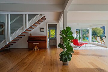 A living room with a piano and a red chair