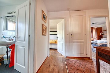 A hallway leading to a bedroom and a bathroom