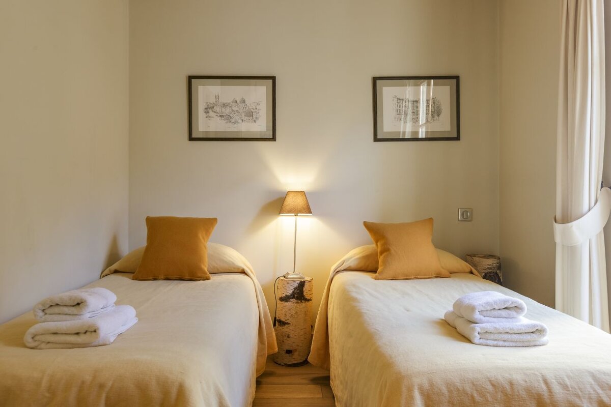A bedroom with two beds and two pictures on the wall