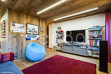 A living room with a blue bean bag chair and a sign that says alexis
