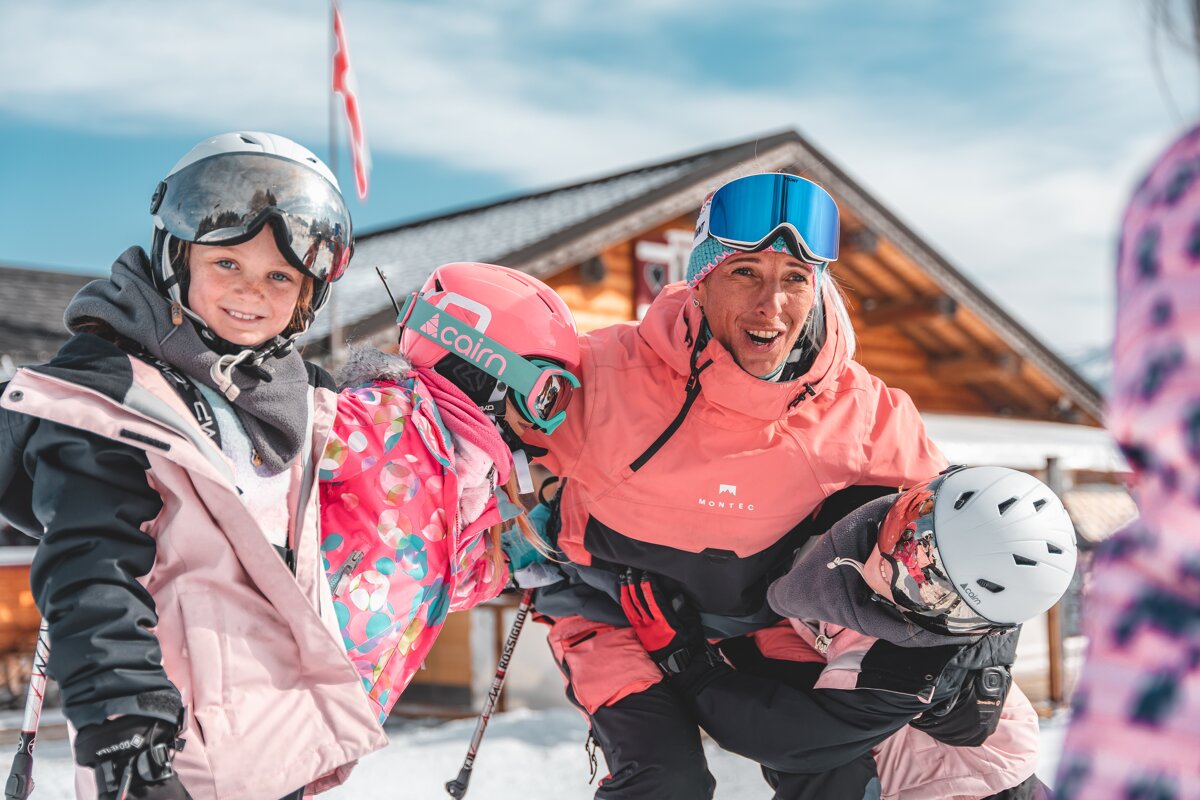 A woman wearing a pink jacket with the word alain on it