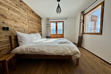A bedroom with a large bed and a window