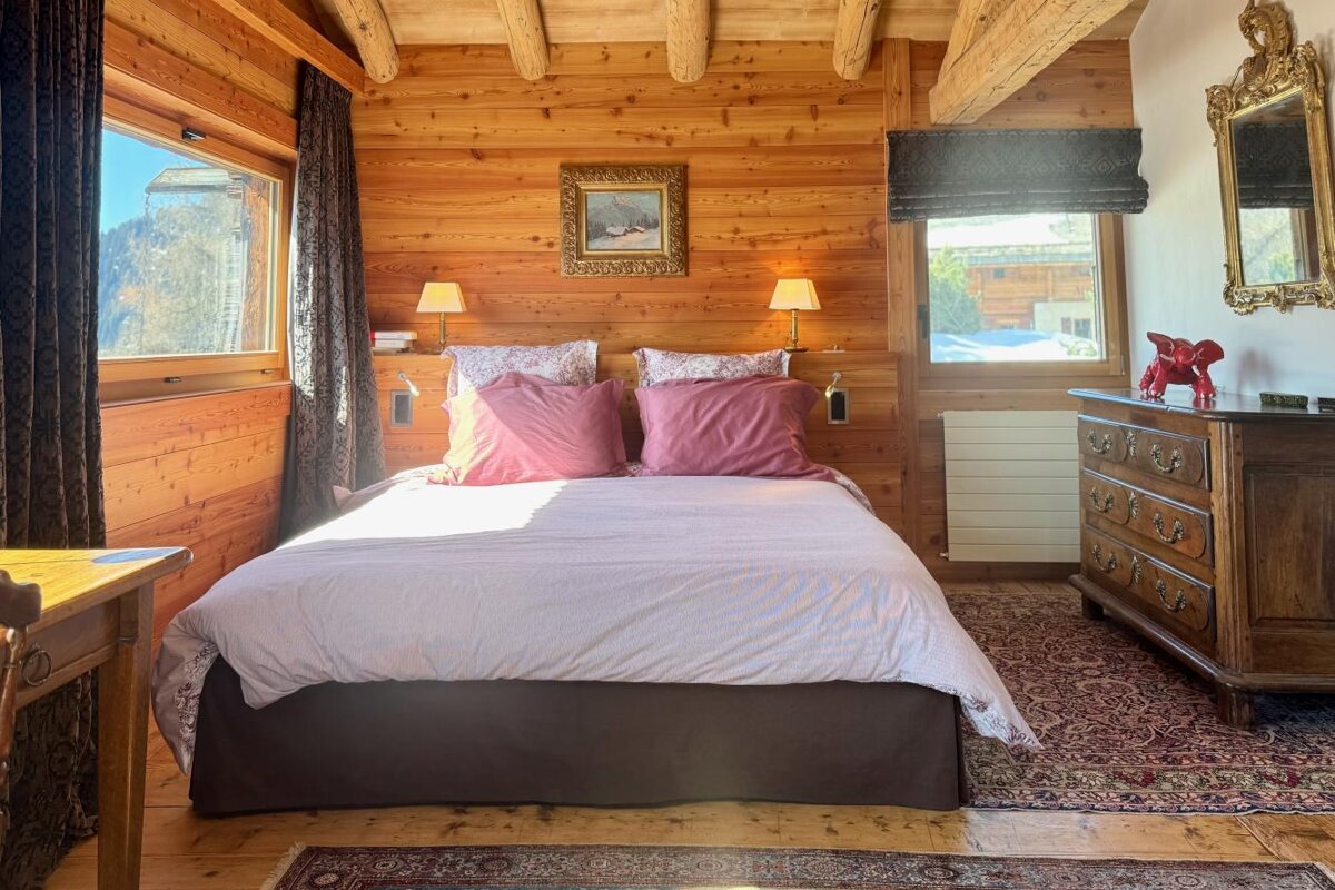 A bedroom with a large bed and a dresser