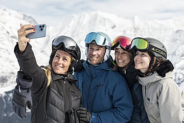 A woman wearing a calm helmet takes a selfie with her friends