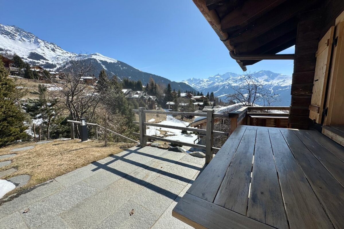 A wooden deck overlooking a snowy mountain range