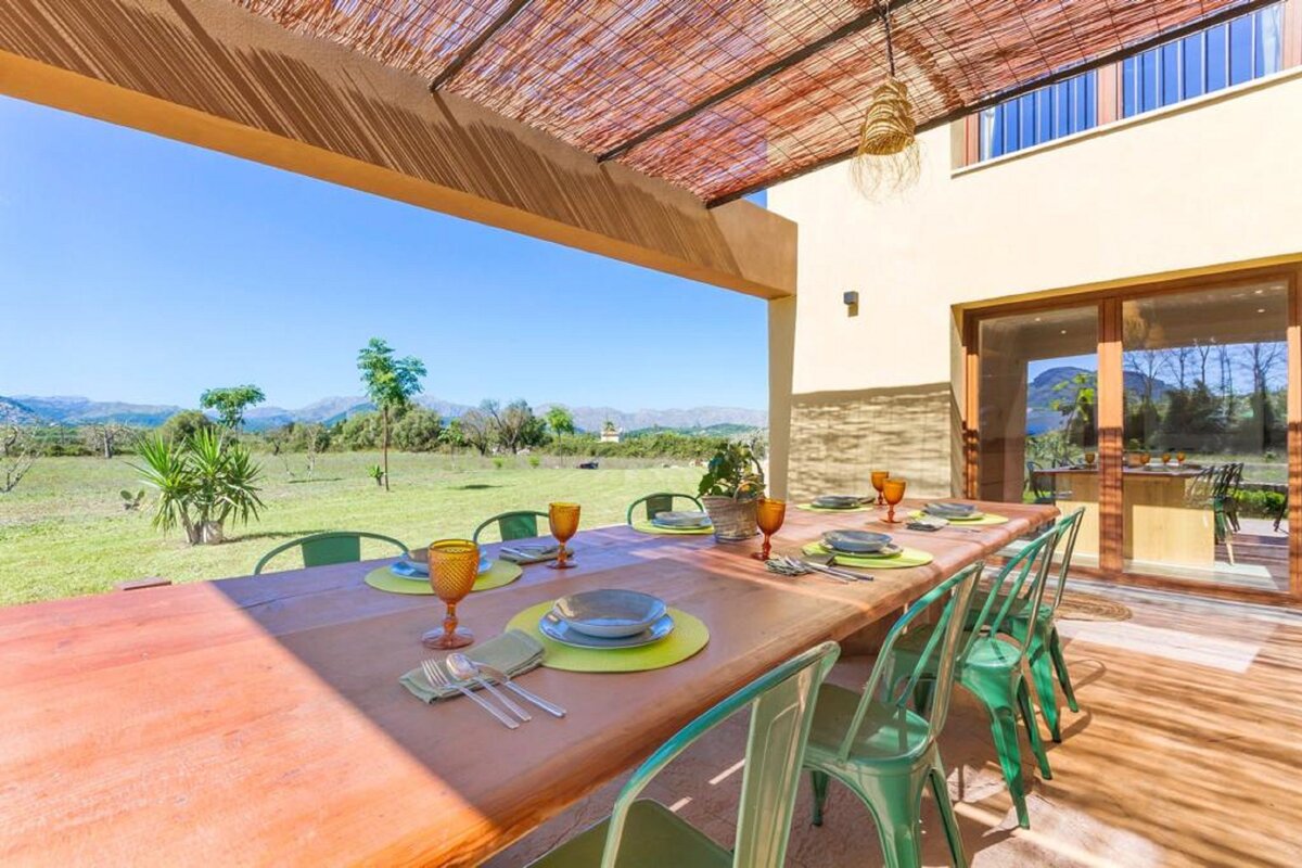 A long wooden table with plates and glasses on it