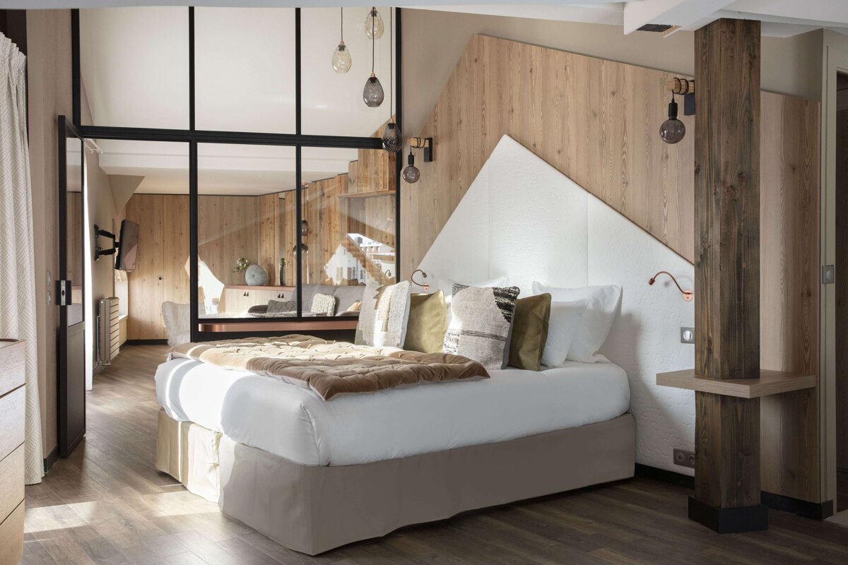 A bedroom with a bed and a wooden wall