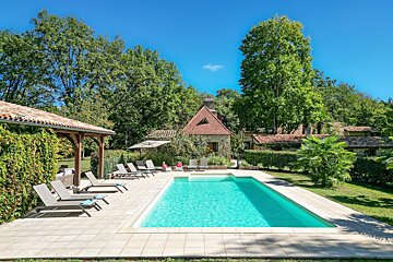 A large swimming pool surrounded by chairs and umbrellas