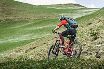 A person riding a bike down a grassy hill