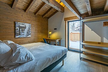 A bedroom with a painting of a ski lift on the wall