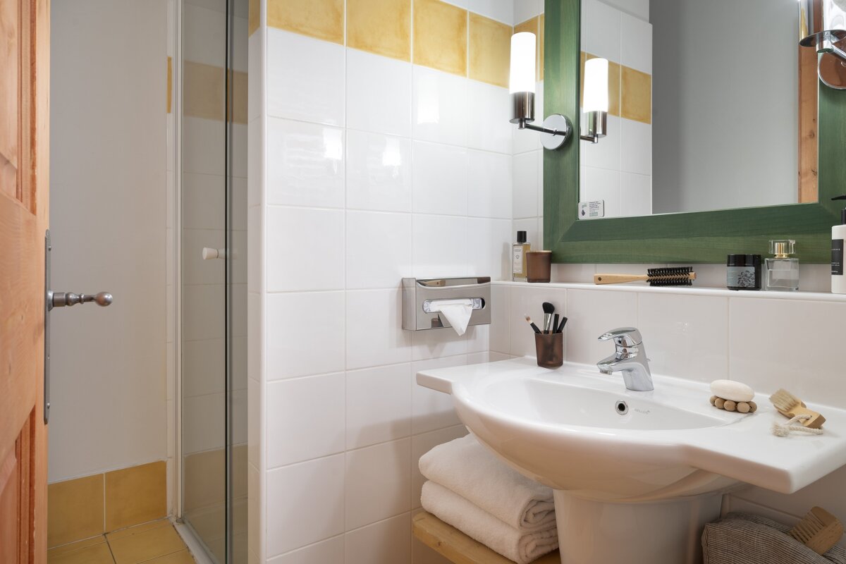 A bathroom with a sink and a green mirror