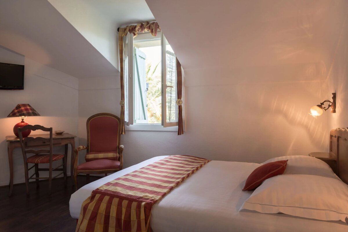 A bedroom with a bed a chair and a window