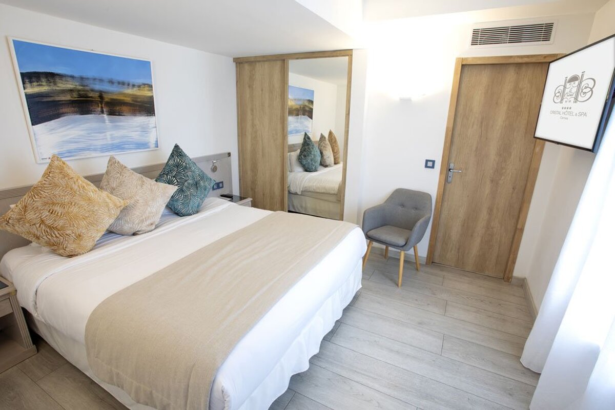 A hotel room with a large bed and a chair