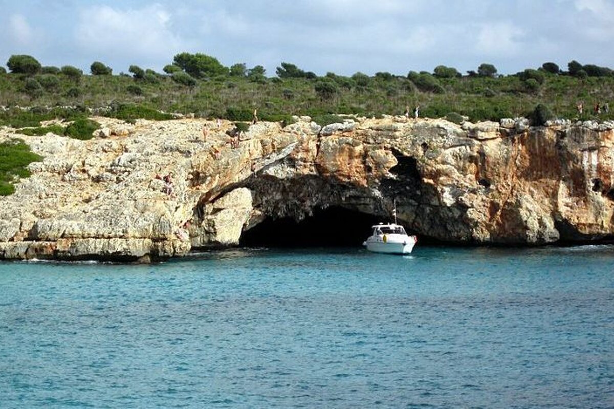 a boat under a sea arch at a climbing venue in Mallorca