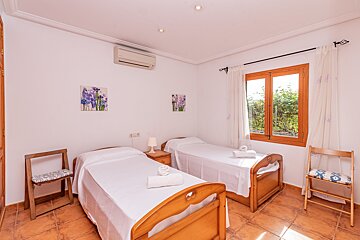 A bedroom with two twin beds and two paintings on the wall