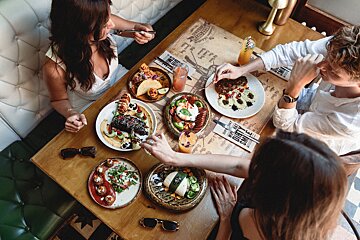 A group of people sitting at a table with plates of food