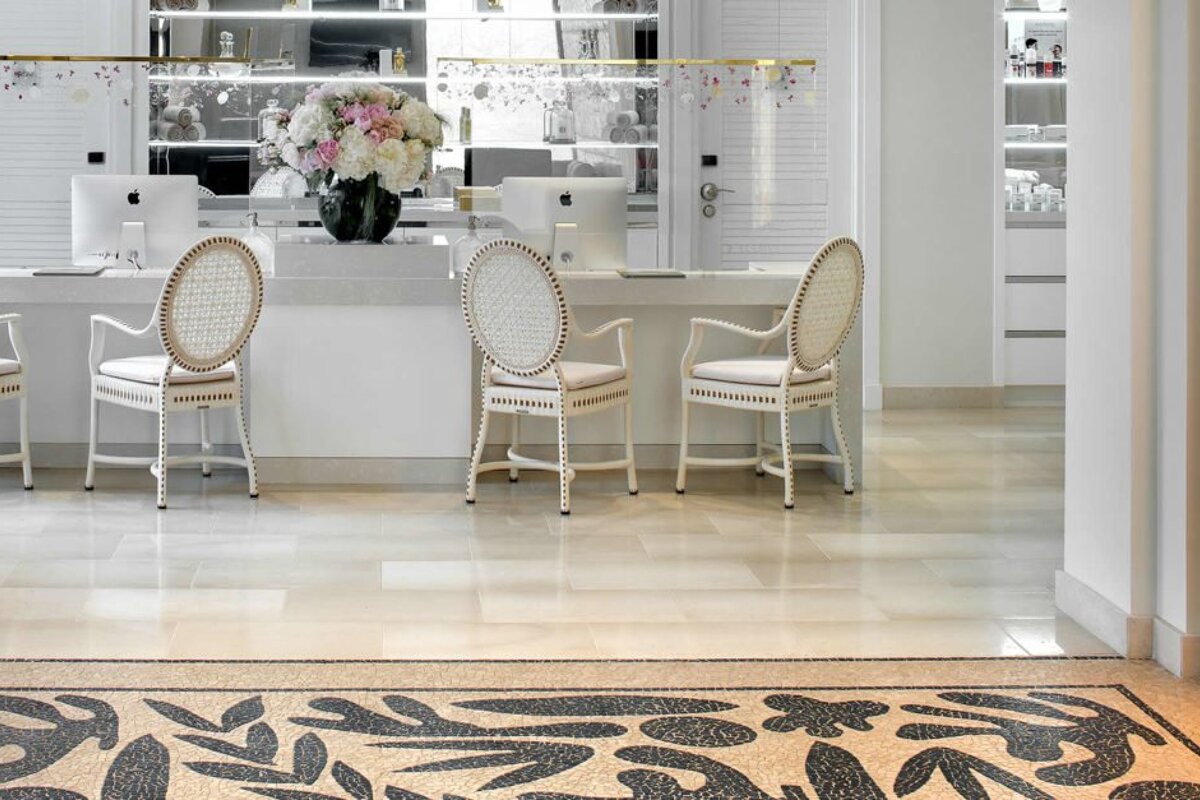A desk with two chairs and a vase of flowers on it