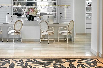 A desk with two chairs and a vase of flowers on it