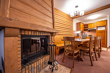 A dining room with a fireplace and a table and chairs