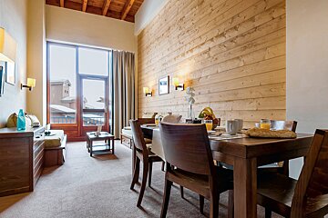 A living room with a table and chairs and a large window