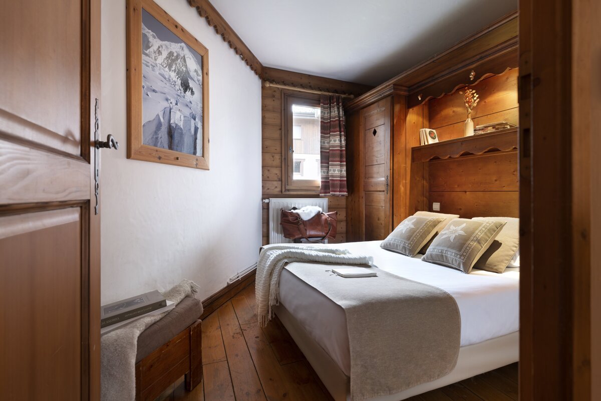 A bedroom with a bed and a picture on the wall