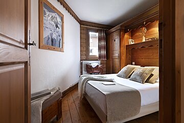 A bedroom with a bed and a picture on the wall