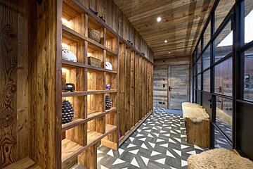 A hallway with wooden shelves and a black and white tile floor