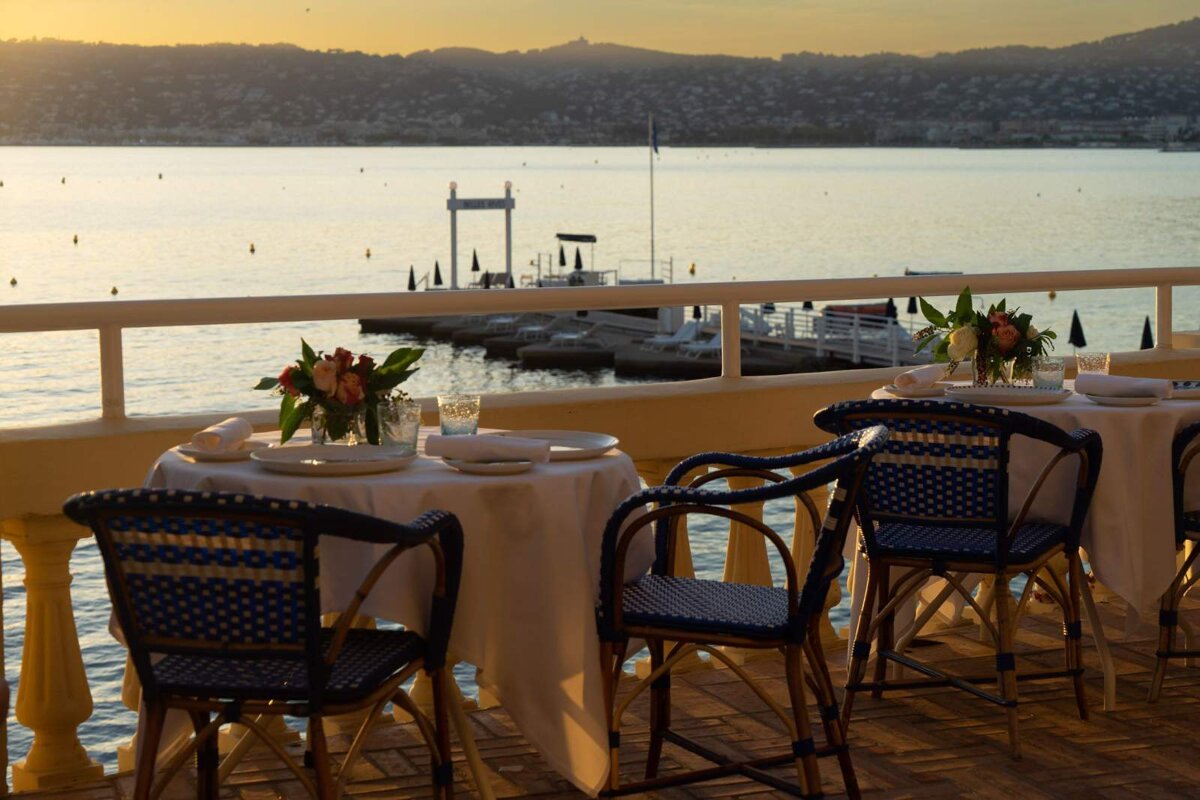 Tables and chairs on a balcony overlooking a body of water