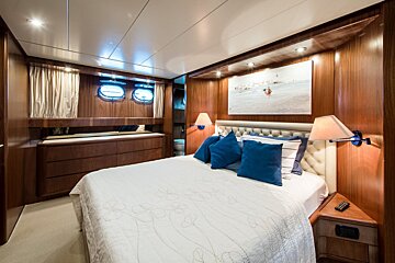 A bedroom with a large bed and blue pillows