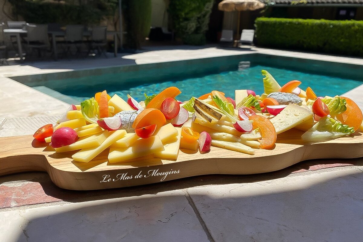 A wooden cutting board that says les mas de mougins on it