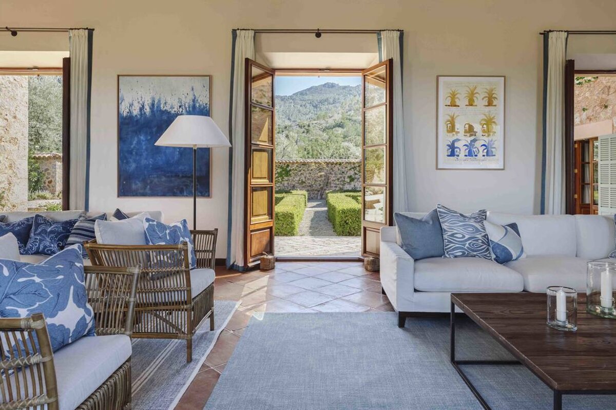 A living room with a couch and chairs and a painting on the wall