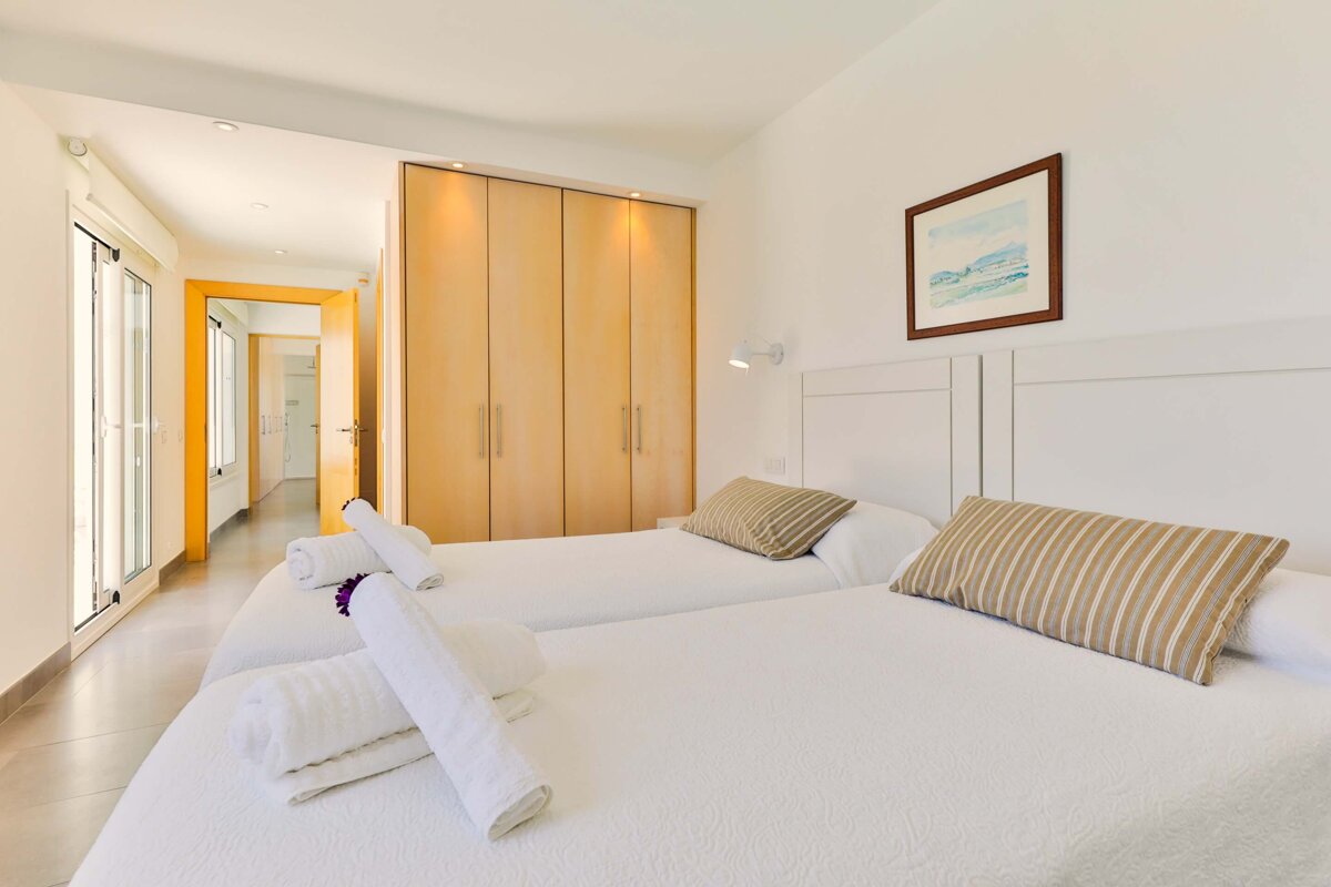 A bedroom with two beds and a picture on the wall