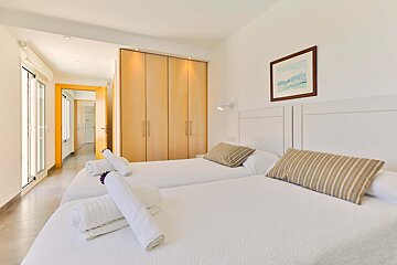 A bedroom with two beds and a picture on the wall