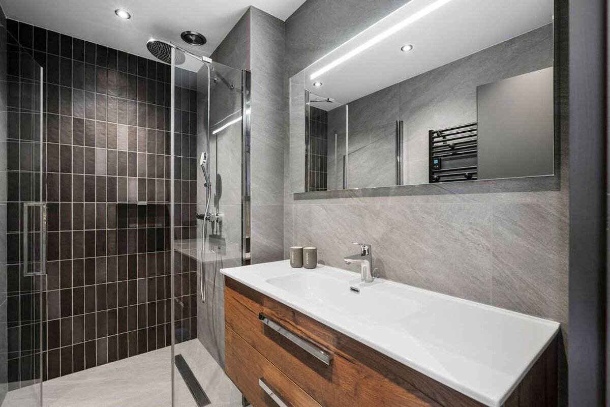 A bathroom with a sink and a walk in shower