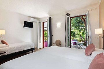 A hotel room with two beds and a television