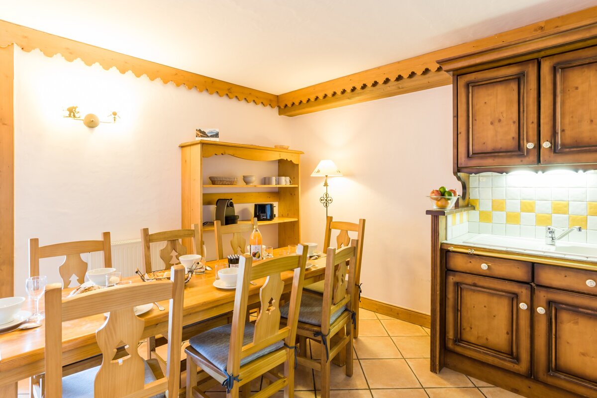 A kitchen with a table and chairs and a sink