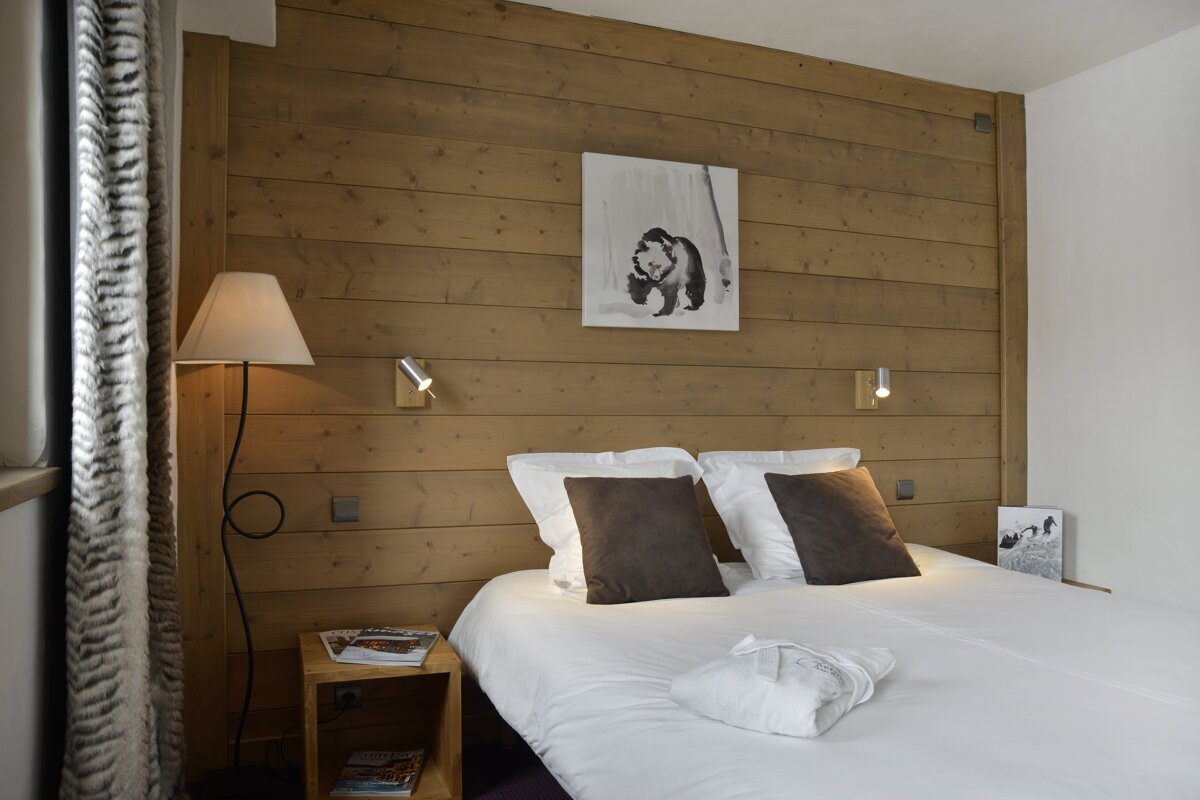 A bedroom with a picture of a bear on the wall above the bed