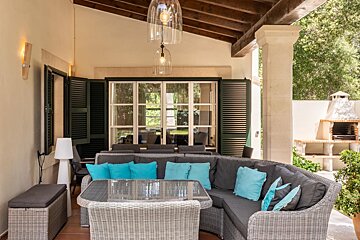 A patio with a couch and a table with blue pillows