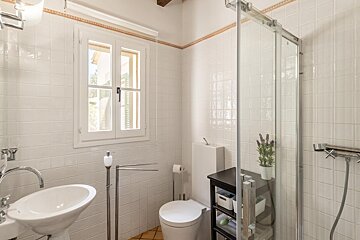 A bathroom with a toilet a sink and a window