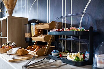A buffet table with a variety of food including bread and cheese